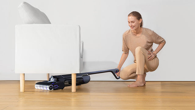 Person using the Narwal S20 Pro cordless vacuum mop to clean under a couch, demonstrating its ease of maneuverability.