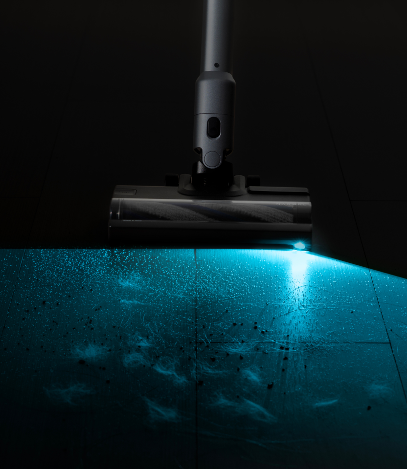 Low aqua light from the Narwal V50 Cube revealing floor dust
