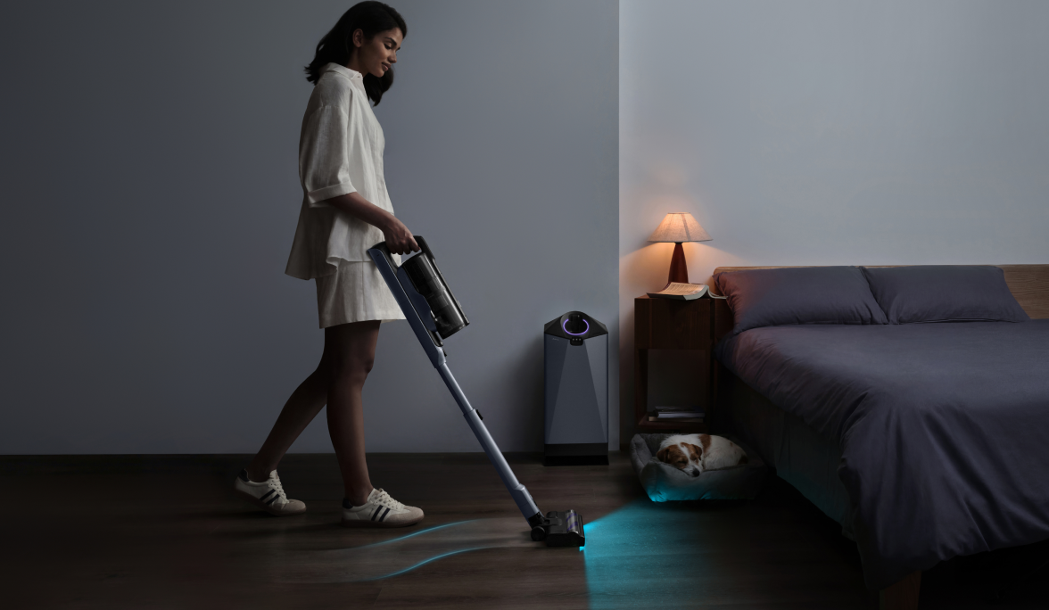 Woman vacuuming a dim bedroom with the Narwal V50 Cube
