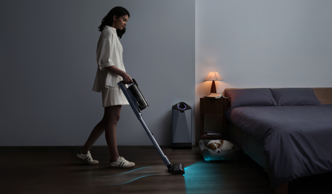 Woman vacuuming a dim bedroom with the Narwal V50 Cube