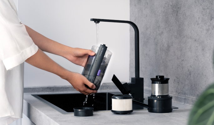 Person rinsing a Narwal V50 Cube filter at a sink