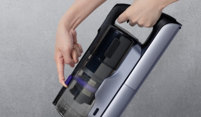 Person operating the Narwal V50 Cube dust cup scraping mechanism
