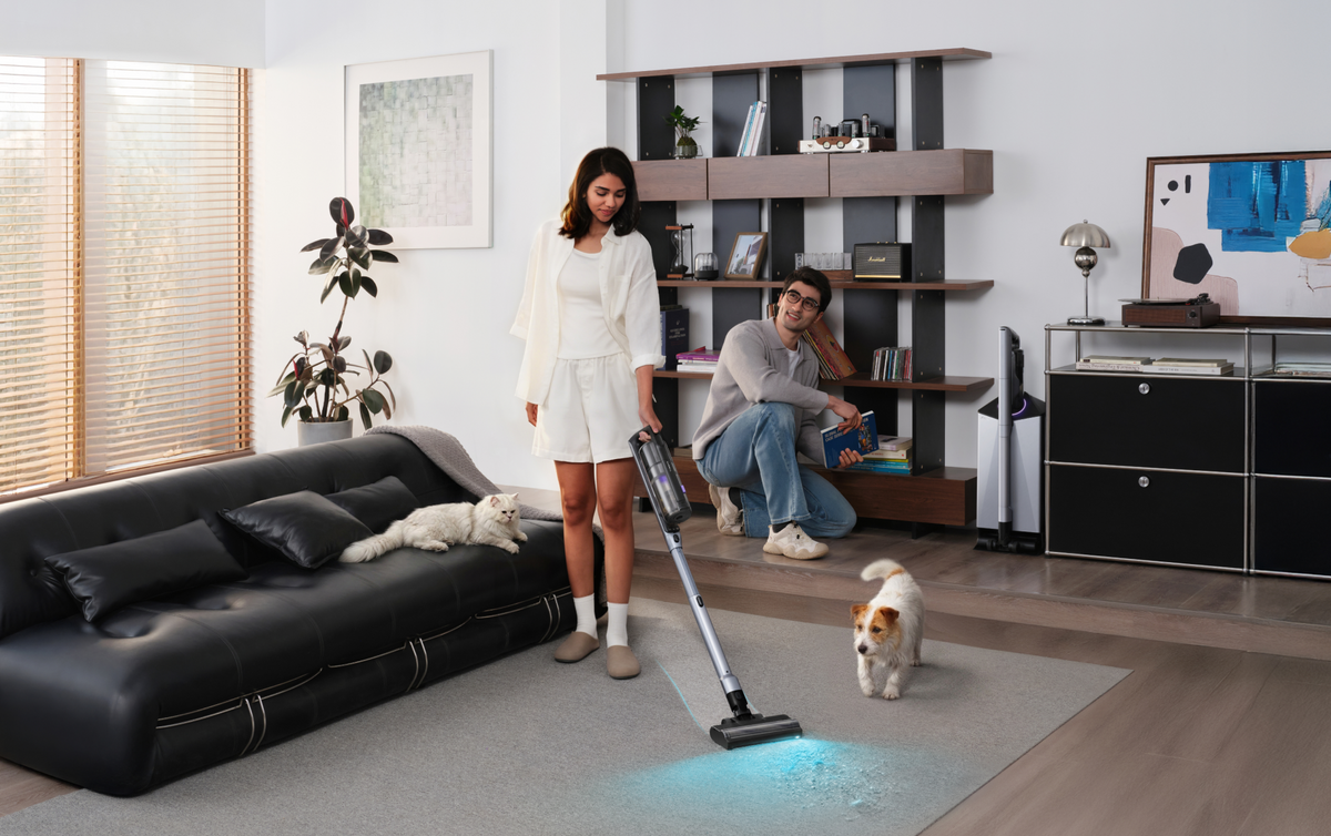 Woman vacuuming with the Narwal V50 Cube while a man and pets look on