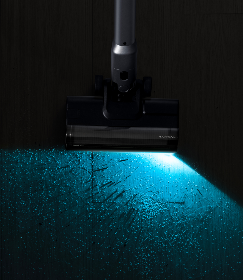 Narwal V50 Cube casting a wide aqua beam across a dusty floor
